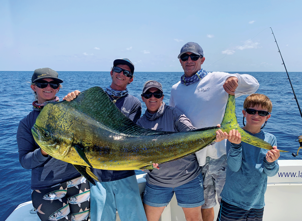 A family holds up a dorado.