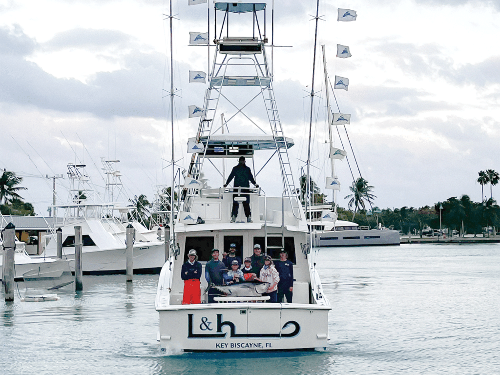 A family stands in the cockpit of a sport-fishing boat.