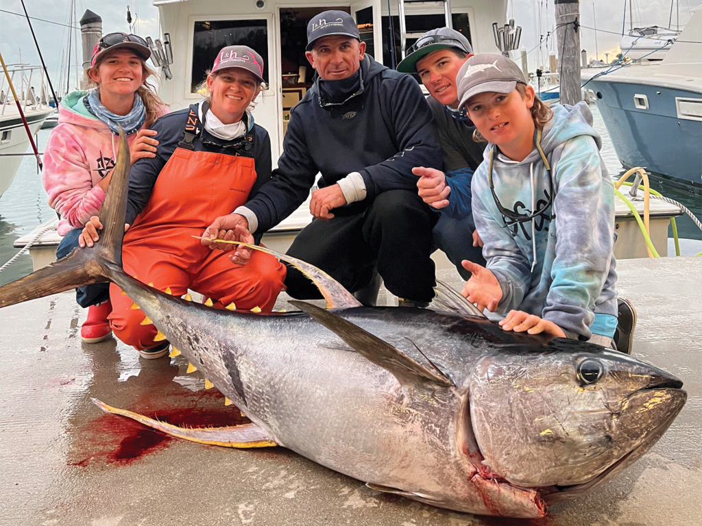 A family next to a bluefin tuna.
