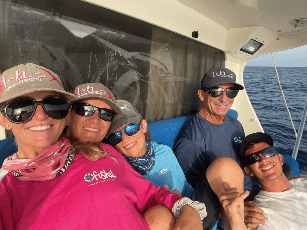A family relaxes in the mezzanine of a sport-fishing boat.