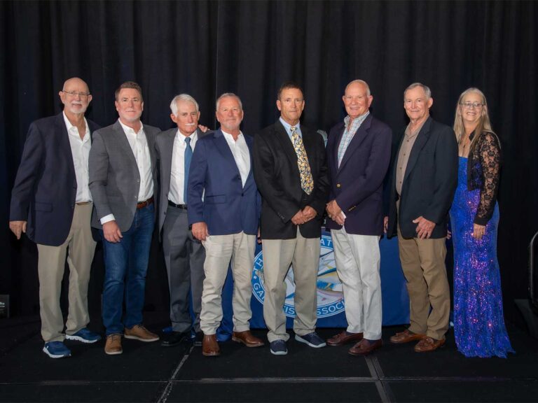Seven men and one woman stand together and pose at an Awards Ceremony