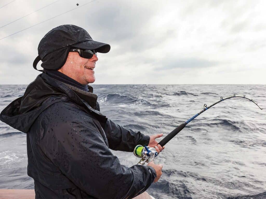 Bill Buckland fishing from the cockpit of a sport-fishing boat.
