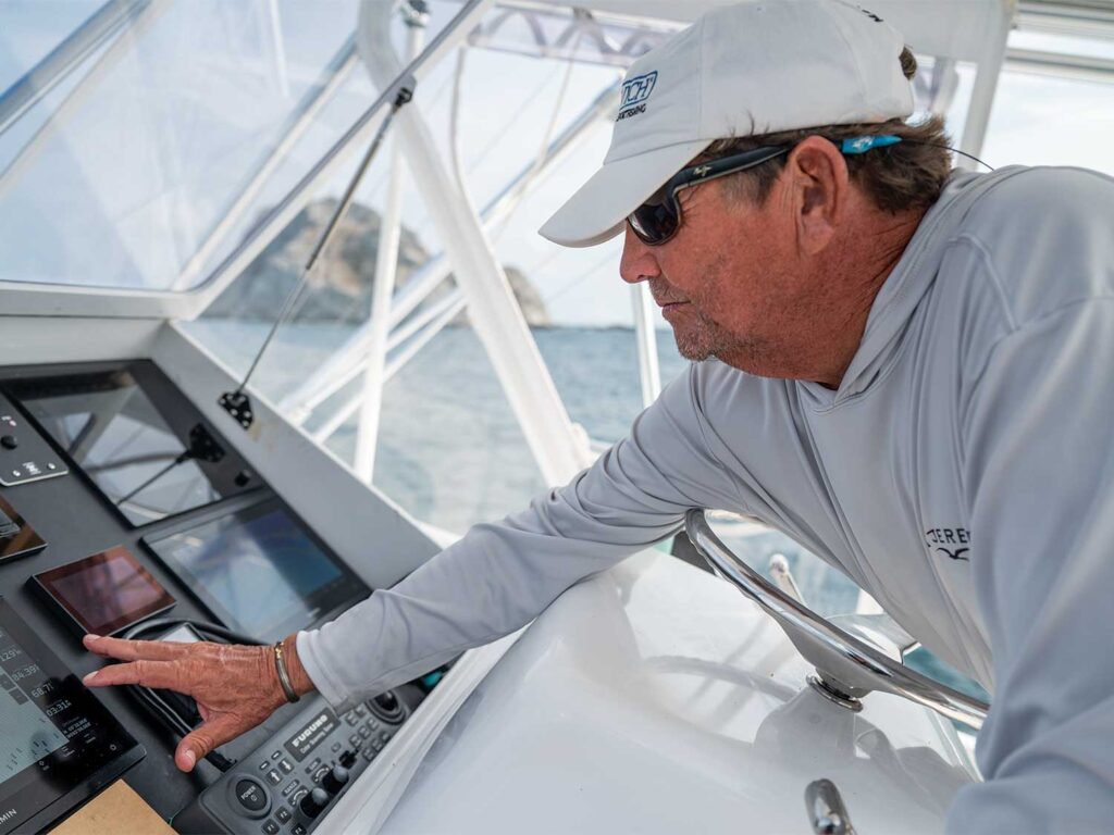 A boat captain checks the digital displays and radar in the helm.