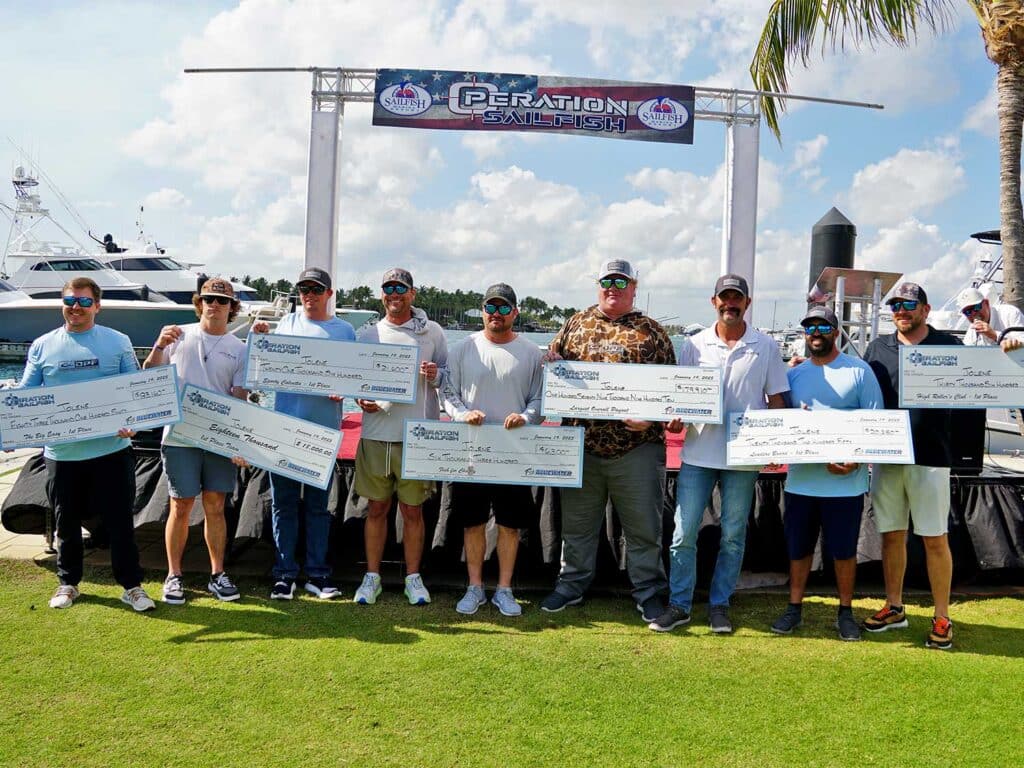 Team Jolene stand at the awards ceremony holding oversized checks.