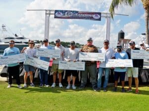 Team Jolene stand at the awards ceremony holding oversized checks.