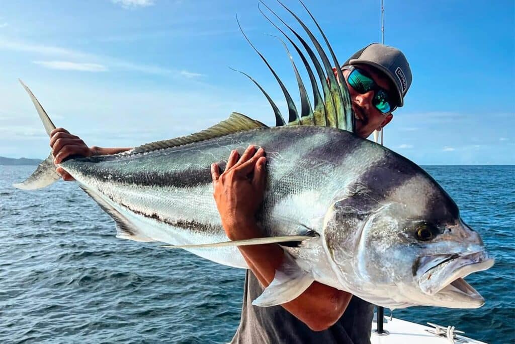Angler holding up a large Roosterfish.