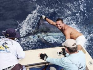 An angler holding a billfish by the fin.