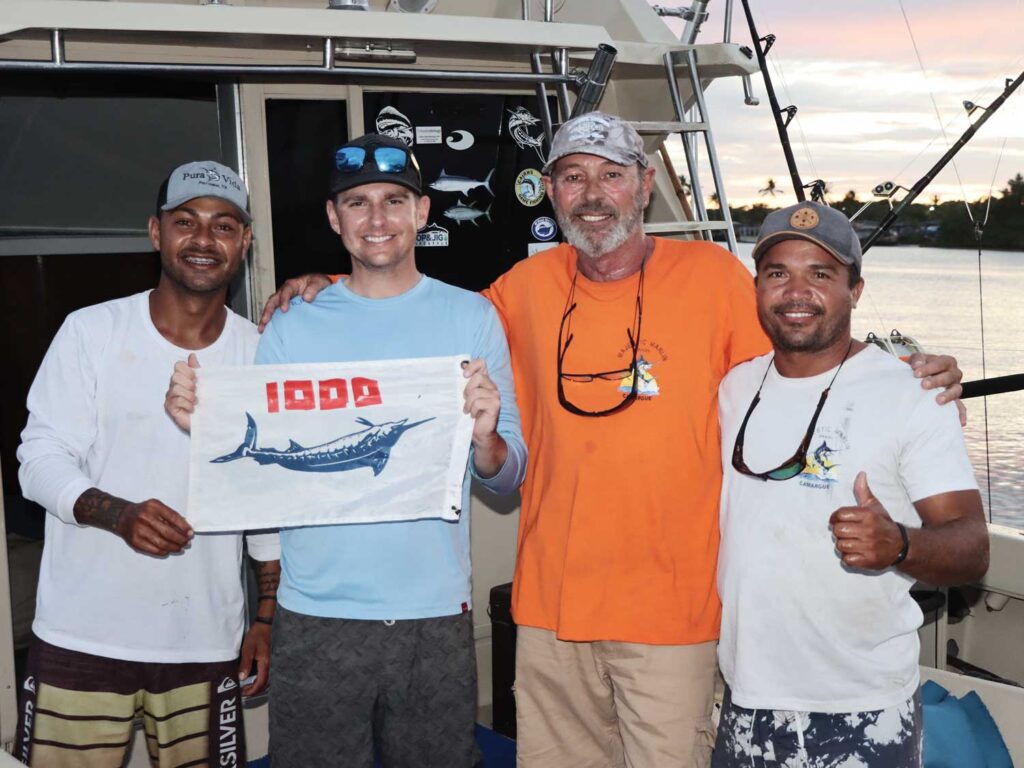 Anglers stand in the cockpit of a sport-fishing boat.