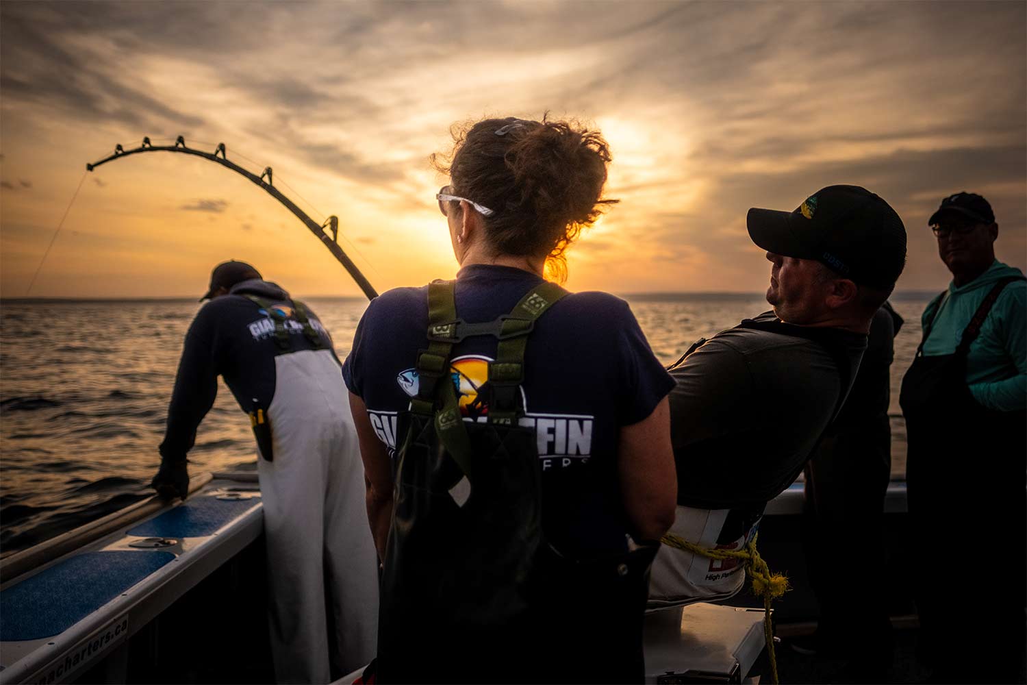 Anglers silhoutted against the sun while they fish.