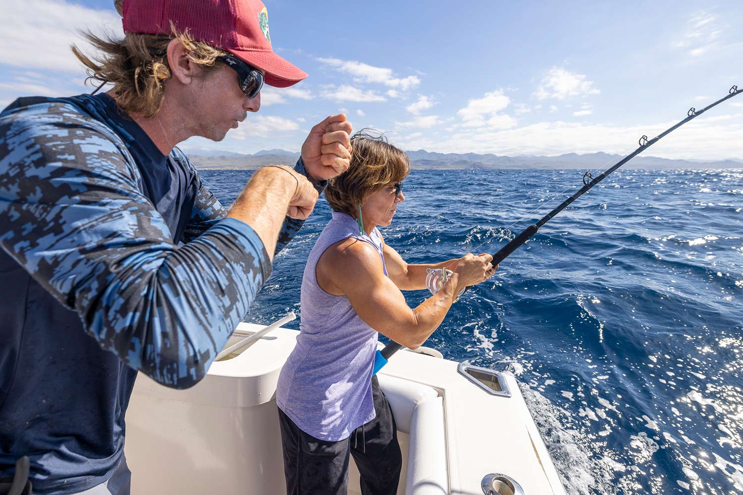 A Marlin Expeditions fishing instructor teaching a client.