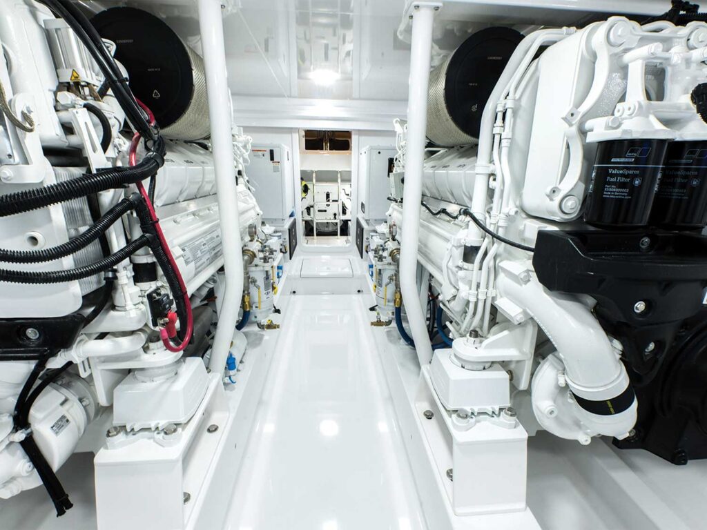 A view of the clean, stark white engine room of a sport-fishing boat.