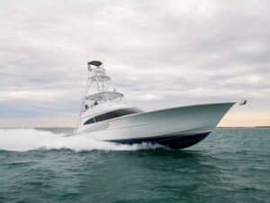 A Winter Custom Yacht painted white glides over the water leaving waves in its wake.