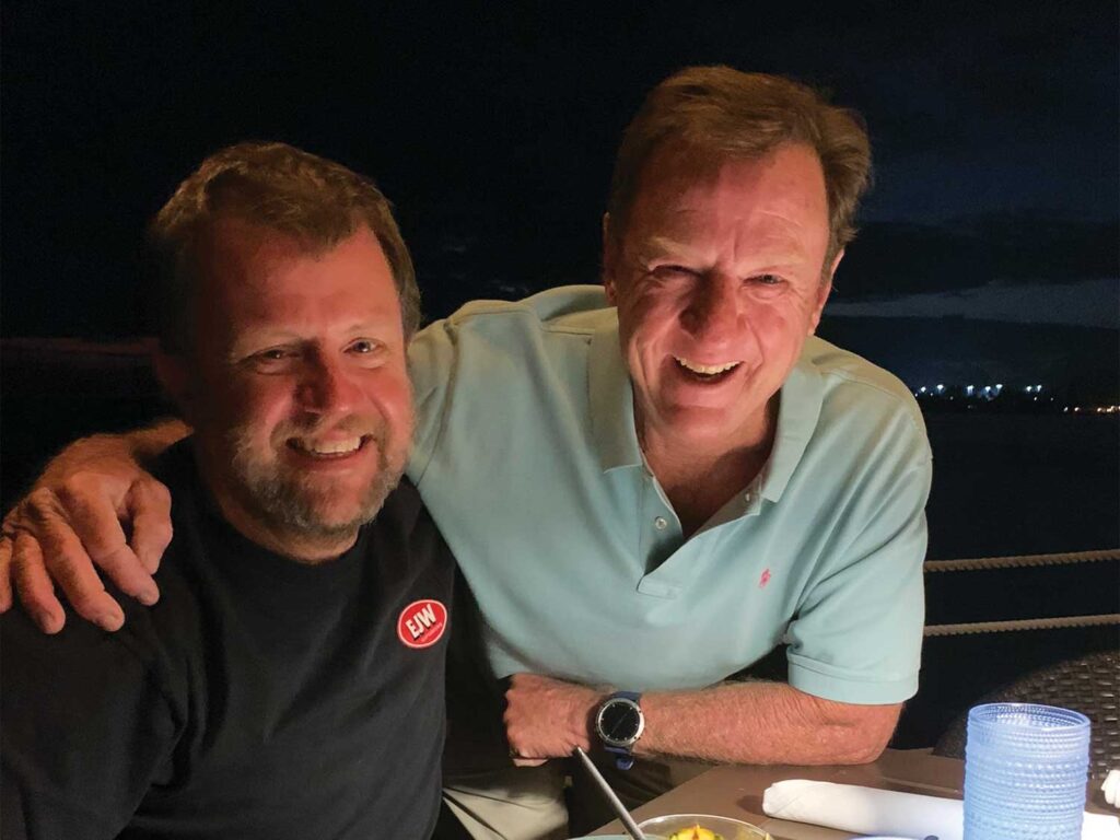 Two men smile and pose for the camera.