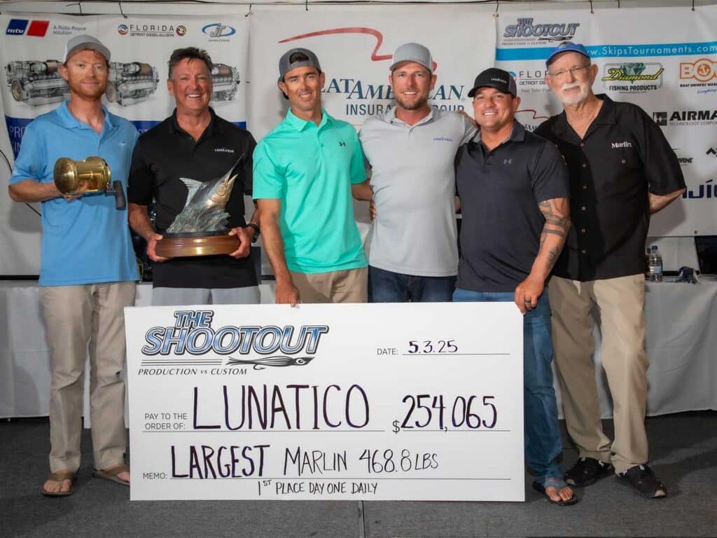 Team Lunatico stands in celebration holding an over-sized check.