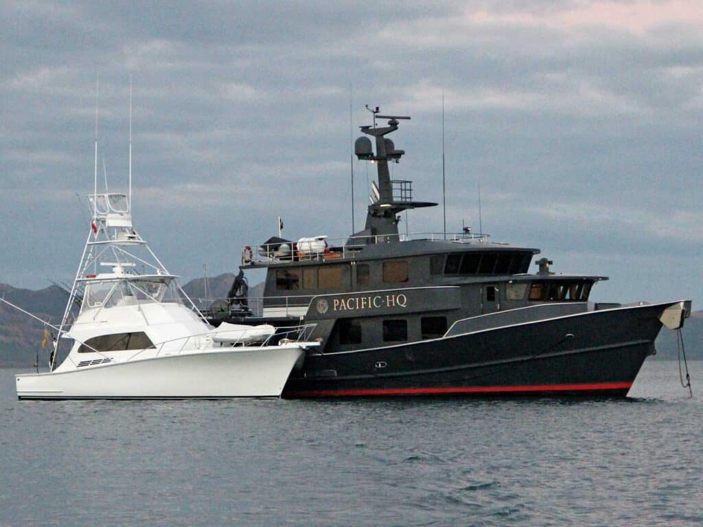 Two sport-fishing boats anchored beside each other on the water.