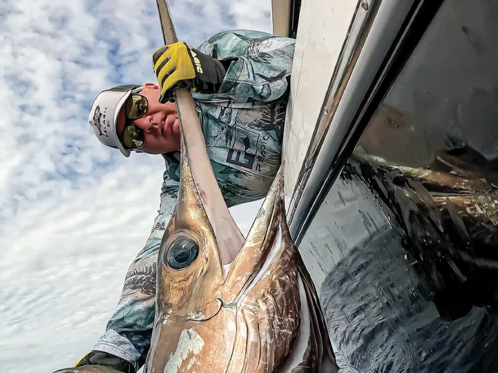 Samuel Urbain pulls a swordfish boatside.