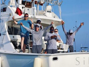 A sport-fishing crew celebrates from the cockpit of a sport-fishing boat.