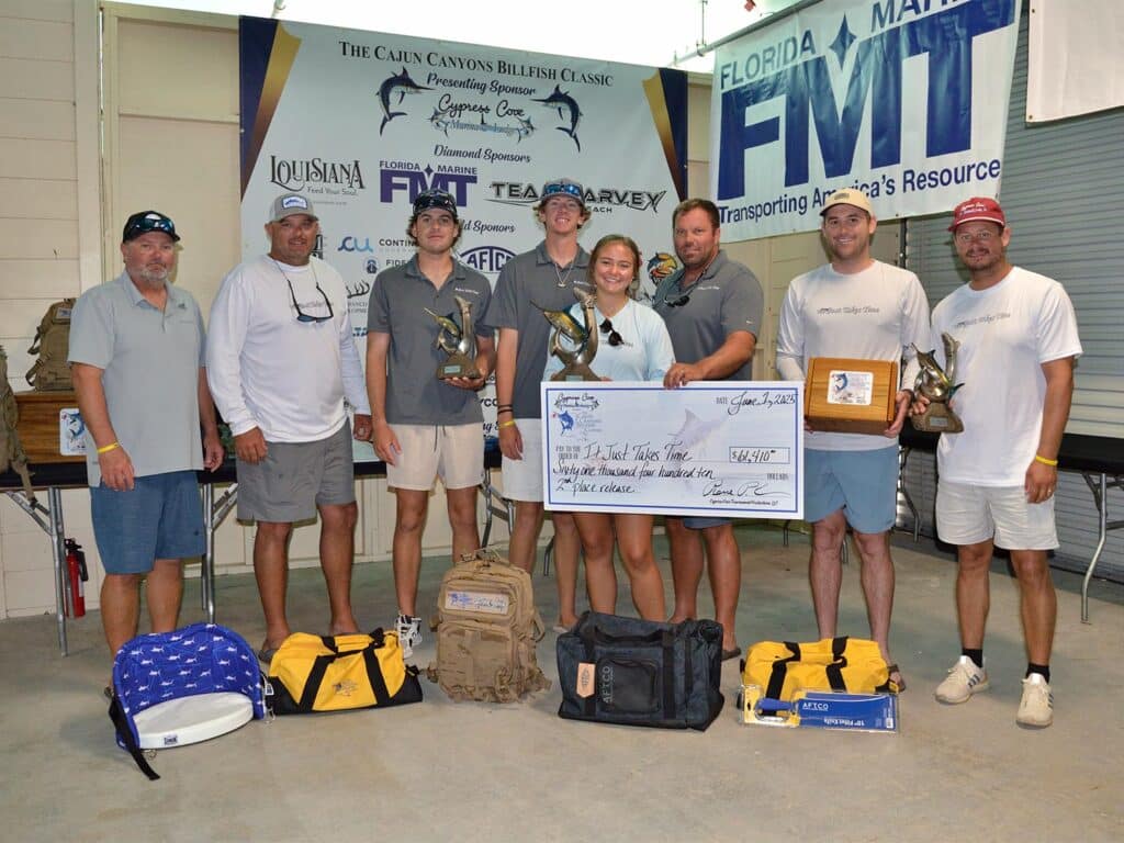 Team It Just Takes Time stands at the awards ceremony holding an oversized check.