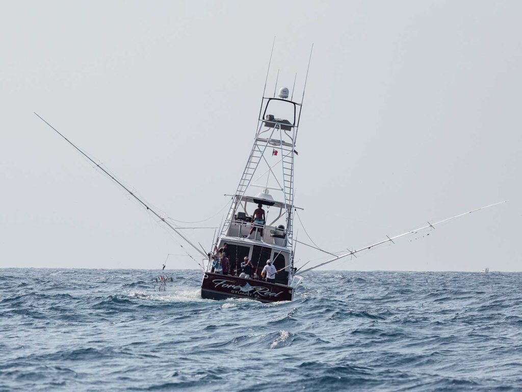 A sport-fishing boat on the water during rough waves.