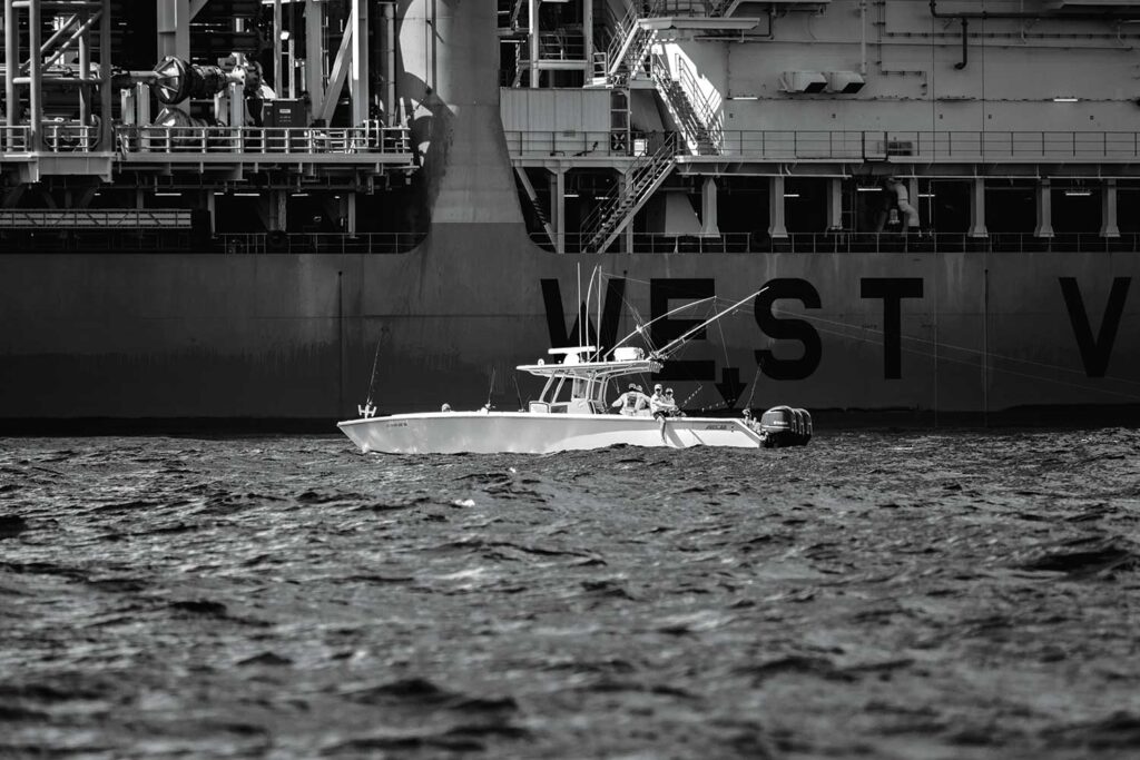 A black and white image of a center-console sport-fishing boat on the water.