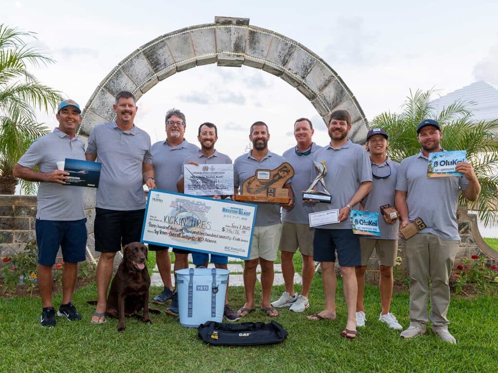 Team Kickin Tires at the awards ceremony of the 2025 Bermuda Billfish Blast. They hold oversized checks, trophies, and awards from tournament sponsors.