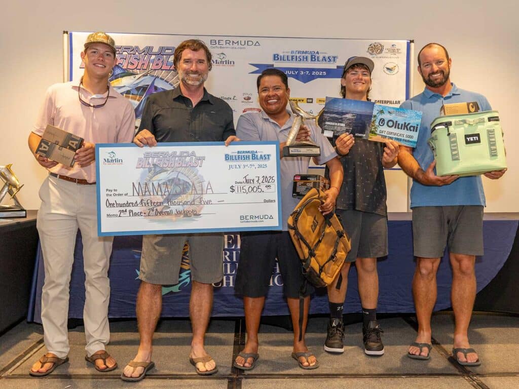 Team Mama Seata at the awards ceremony of the 2025 Bermuda Billfish Blast. They hold oversized checks, trophies, and awards from tournament sponsors.