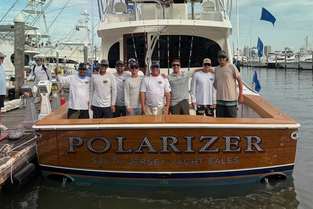 Team Polarizer stands in the cockpit of their sport-fishing boat.