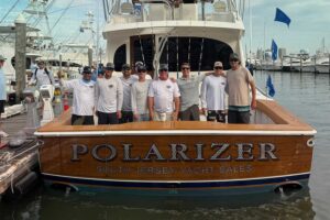 Team Polarizer stands in the cockpit of their sport-fishing boat.