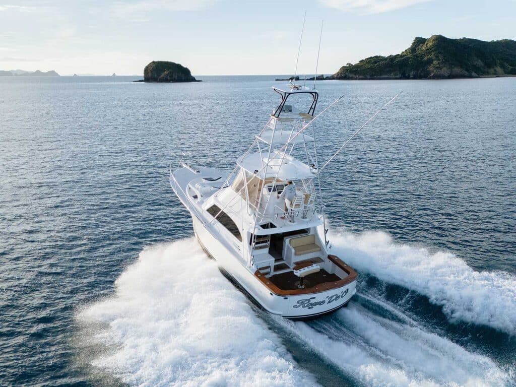 A sport-fishing boat cruises across the New Zealand ocean.