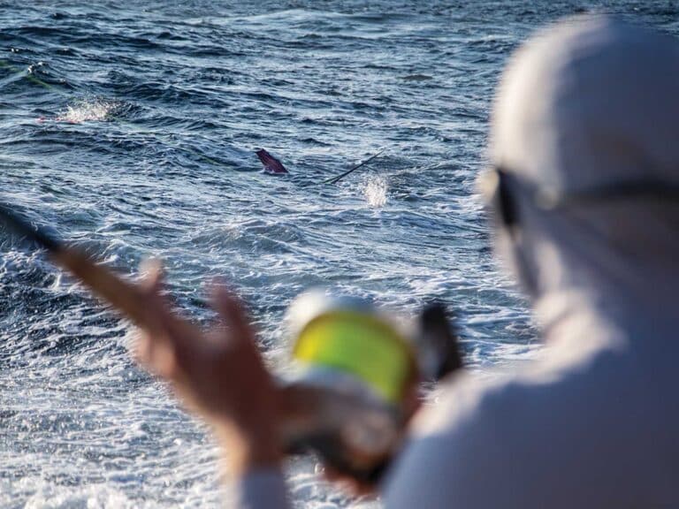 Angler looks on while a marlin is on the line.