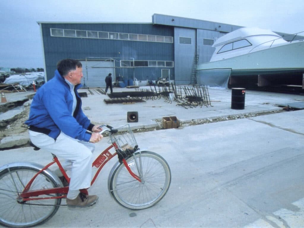 Bill Healey rides a bike through the Viking Yachts warehouse