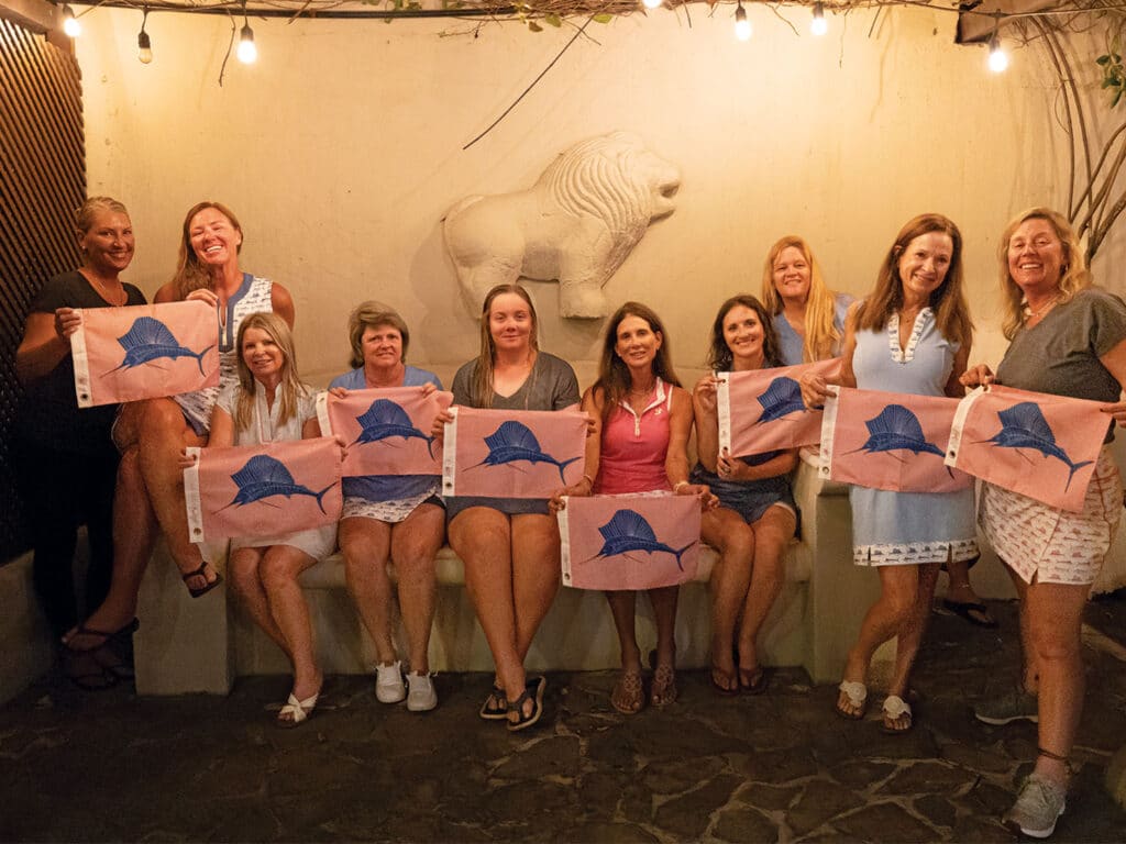 A team of lady anglers stand and pose with sailfish release flags.