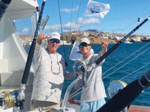 Two anglers in the cockpit of a sport-fishing boat.