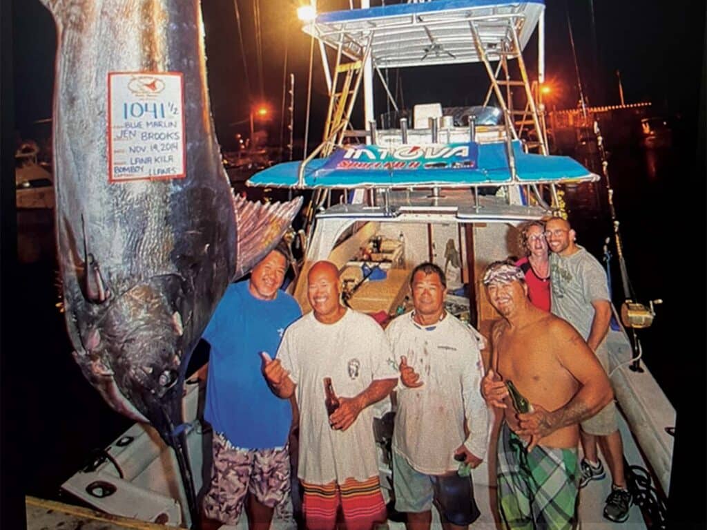 Vintage photo of a team of anglers standing next to a large grander marlin.