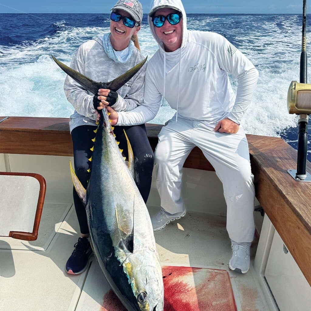 Two anglers pose with an ahi tuna.