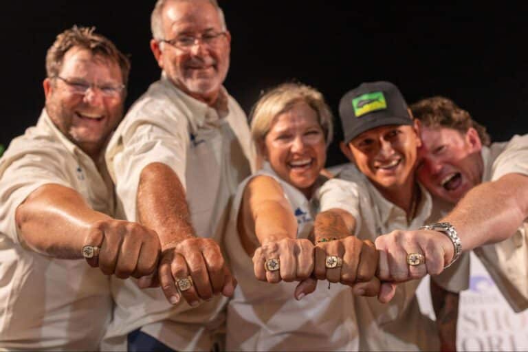 A group of tournament participants showing off their championship rings.