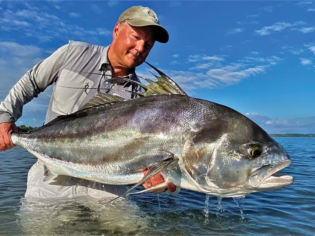 Angler holds up a large roosterfish.