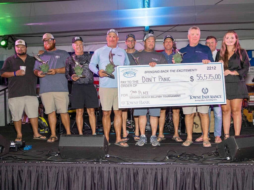 Team Don't Panic at the 2025 Virginia Beach Billfish Tournament Awards ceremony. the team holds up oversized checks and other prizes.