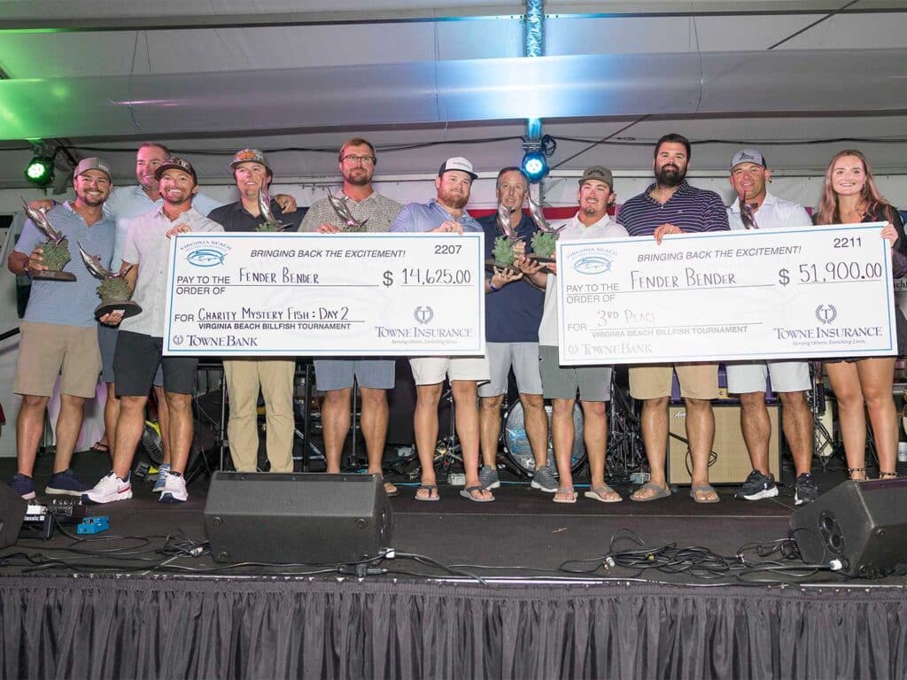 Team Fender Bender at the 2025 Virginia Beach Billfish Tournament Awards ceremony. the team holds up oversized checks and other prizes.