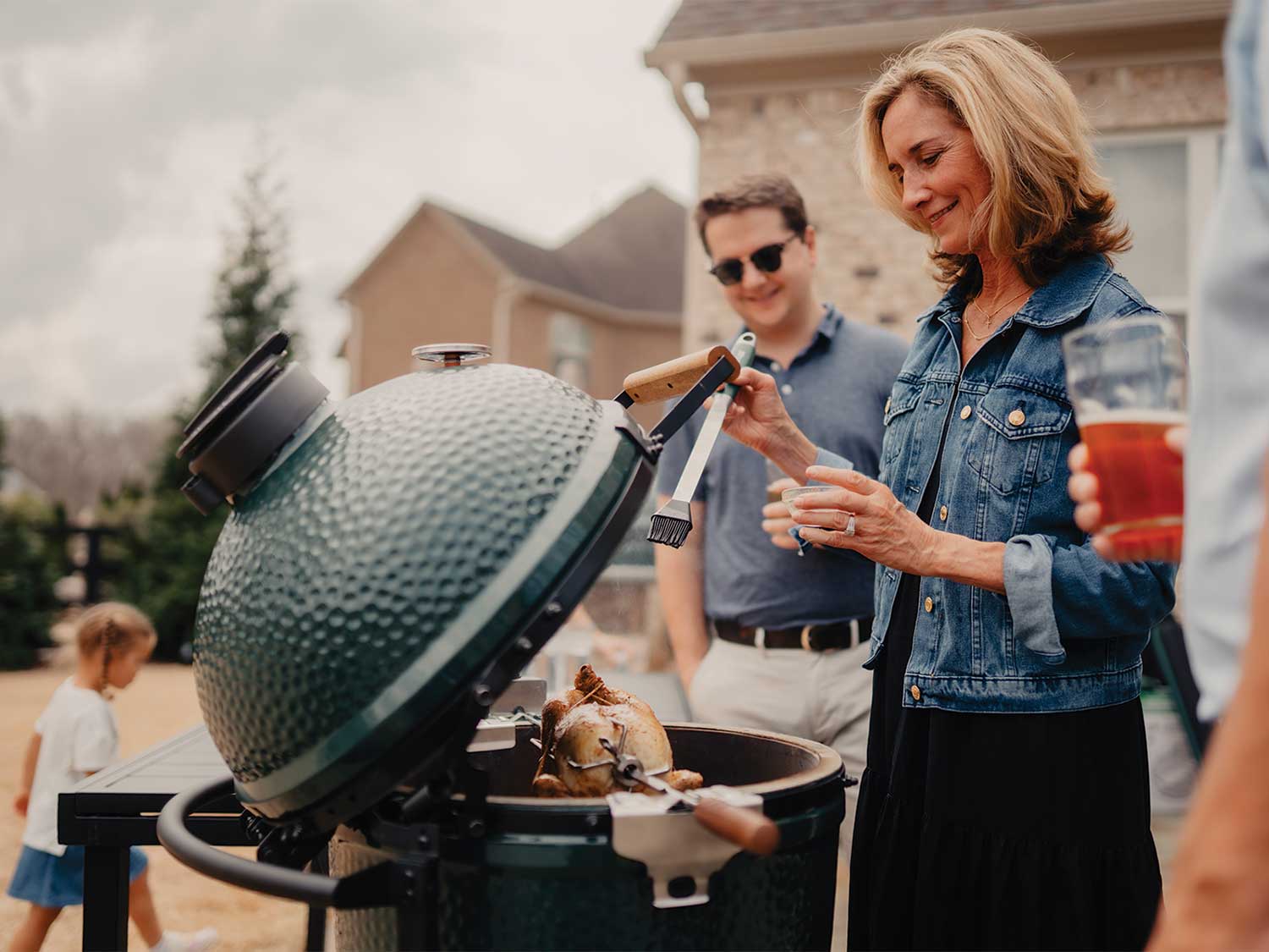 A family around an outdoor Big Green Egg.