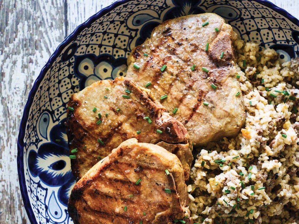 Brined Porterhouse Pork Chops with Roasted Green Tomato and Poblano Dirty Rice