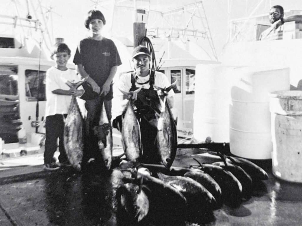 A black and white photo of Rom Whitaker and his young sons.