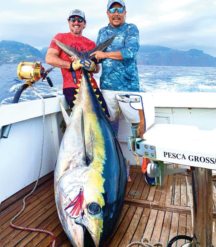 Carey Chen holds up a large bigeye tuna with a fellow angler.