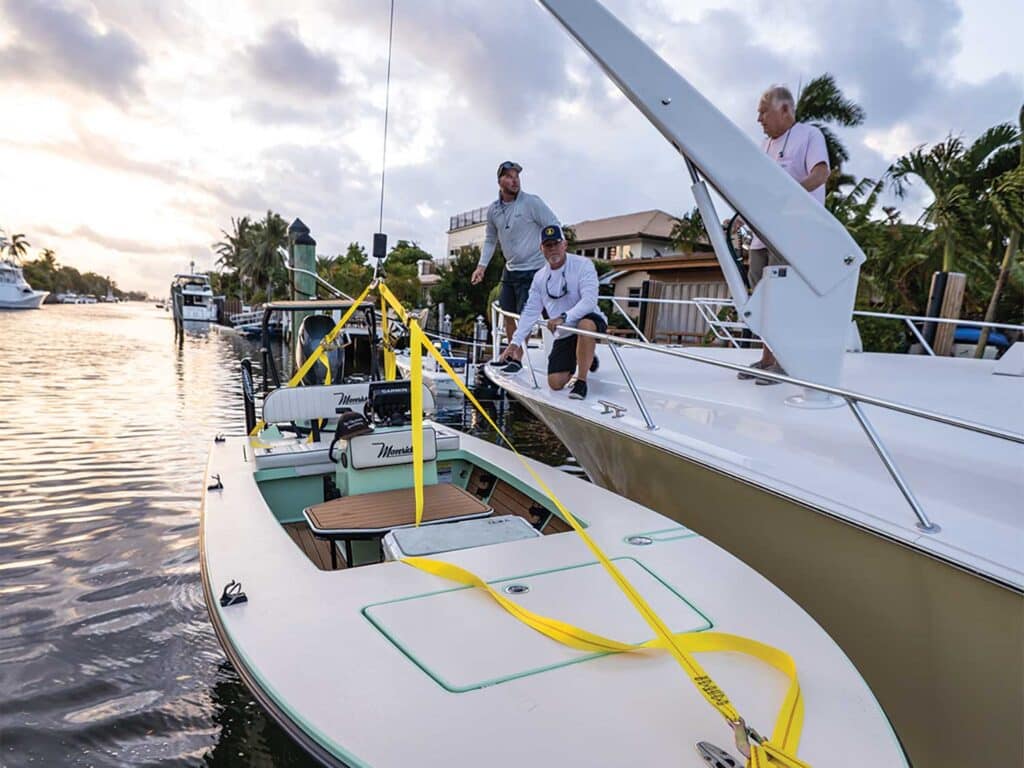 Crew using a lift crane on a skiff.