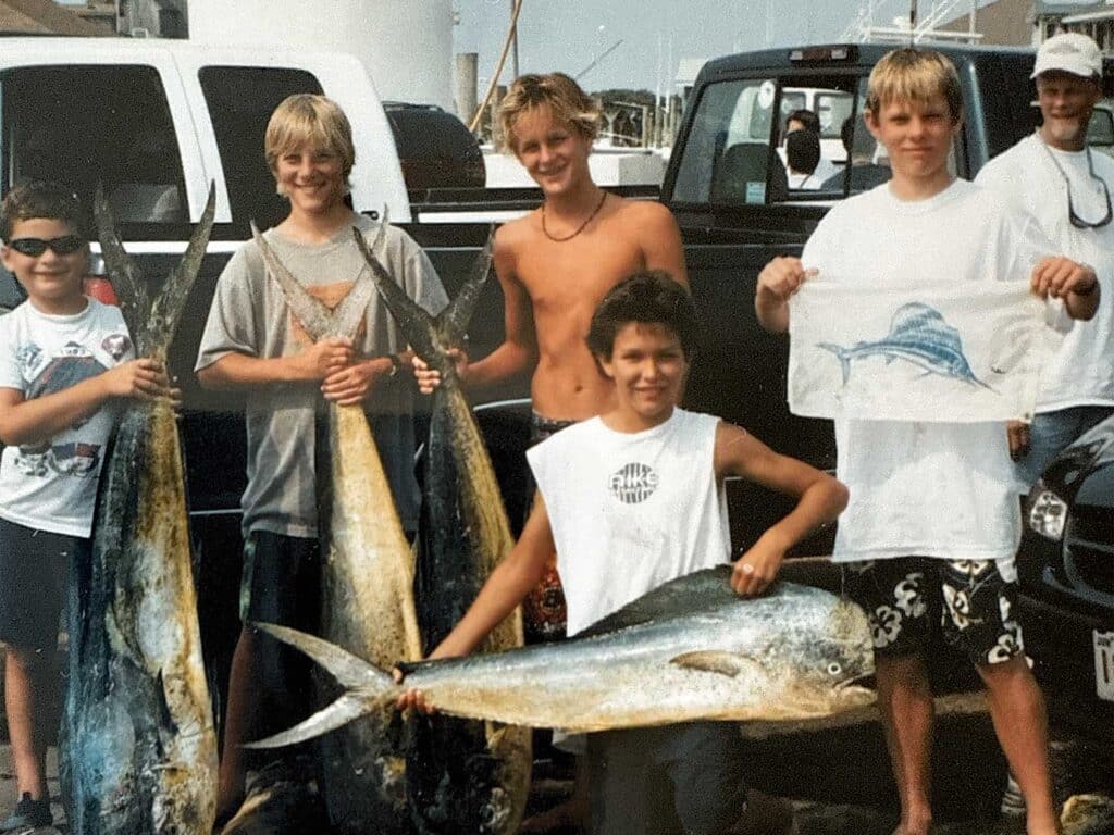 A vintage photo of a young Rom Whitaker surrounded by friends.