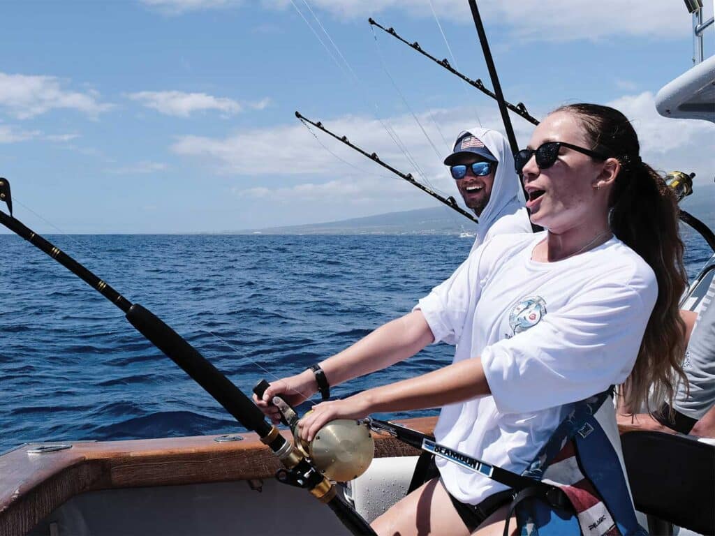 Anglers fish from the cockpit of a sport-fishing boat.