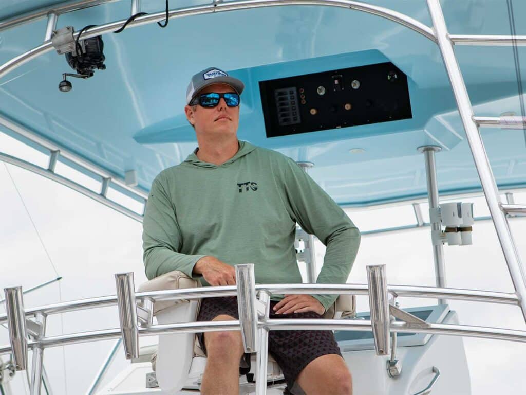 Capt. Nick Durham seated at the helm of a sport-fishing boat.
