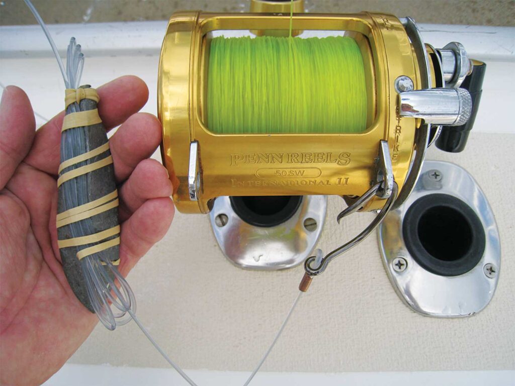 Close up showing a weight rubber-banded to a fishing leader.