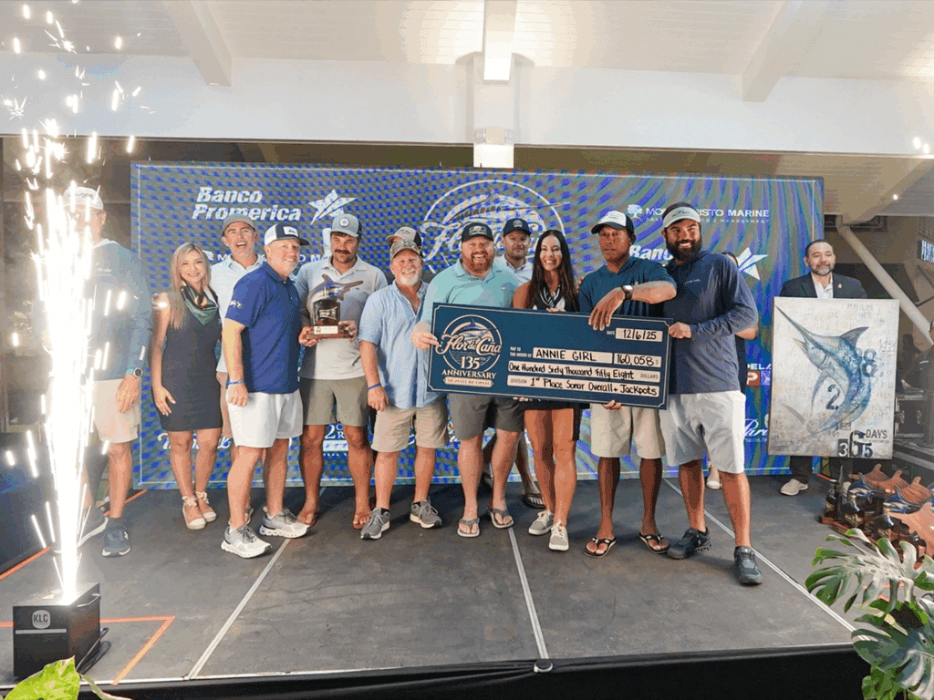 A team of sport-fishing anglers on stage at the 2025 Flor de Cana tournament at Marina Pez Vela. They hold up prizes and awards.