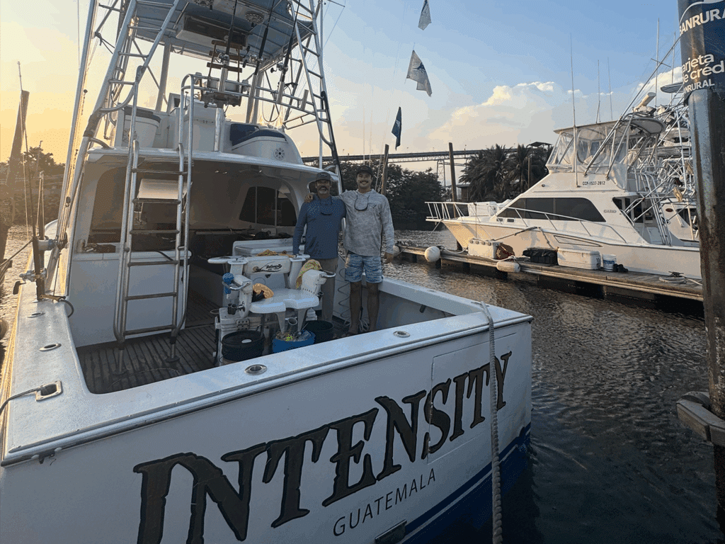 Two anglers standing in the cockpit of a sport-fishing boat.
